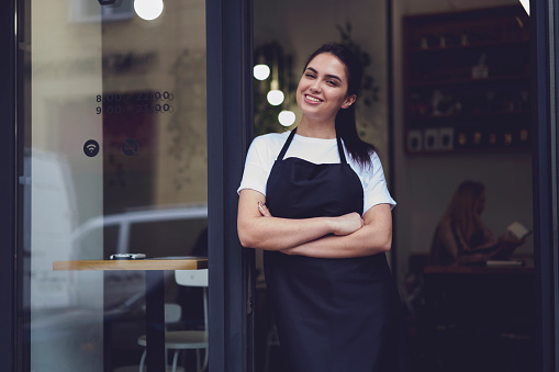 Retrato de atractiva mujer barista en cafetería photo