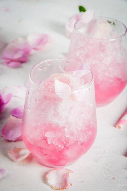 Iced summer dessert Frose Summer refreshing desserts. Vegan diet food. Ice cream frozen rose, froze, with rose petals and rose wine. On a white concrete table, with spoons, striped straws, petals and rose flowers. Copy space frozen rose stock pictures, royalty-free photos & images