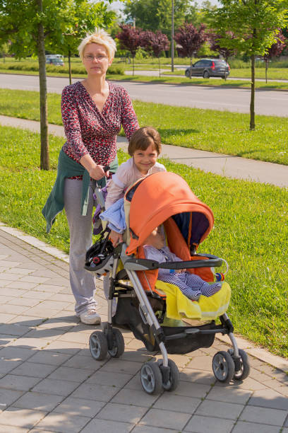istock Mother walking in city with pushchair 693841596