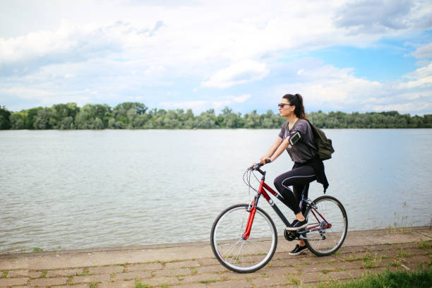 istock Young woman on the bicycle by the river 693847350