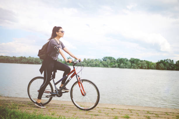 istock Young woman on the bicycle by the river 693848272