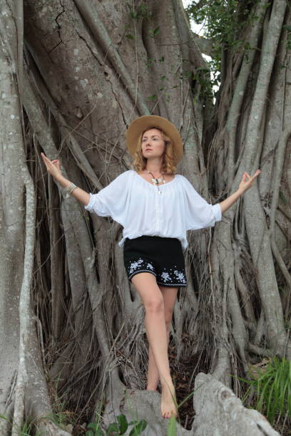 istock Young woman is standing on huge tree roots. 693853718