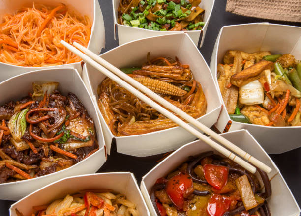 Chinese food in different cardboard boxes Chinese food in different cardboard boxes and wooden sticks chinese takeout stock pictures, royalty-free photos & images