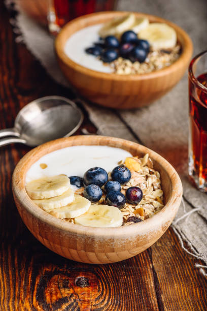 ブルーベリーとバナナとグラノーラの 2 つのボール。 - oatmeal porridge dried fruit bowl ストックフォトと画像