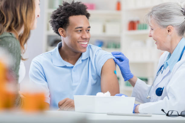 african american erhält grippe-impfstoff - grippeimpfstoff stock-fotos und bilder