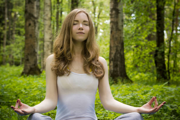 istock A girl is meditating in nature. 693867410