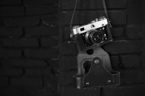 istock Old film camera on black wall. Image for design 693871216