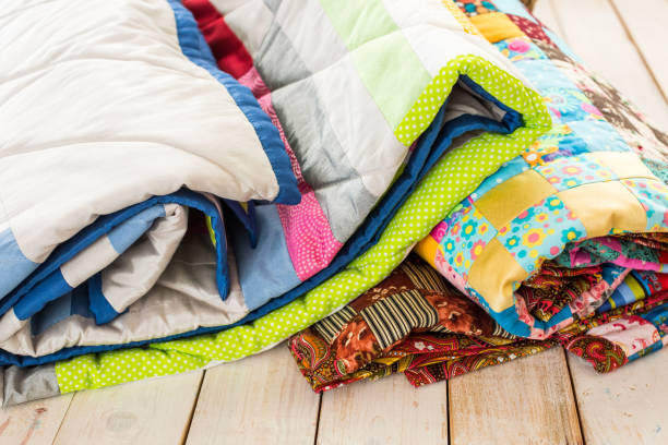 istock patchwork and fashion concept - close-up on beautiful colorful quilts folded on a whitewashed wooden floor, close-up on patchwork products on a white background, top view, vertical 693874216