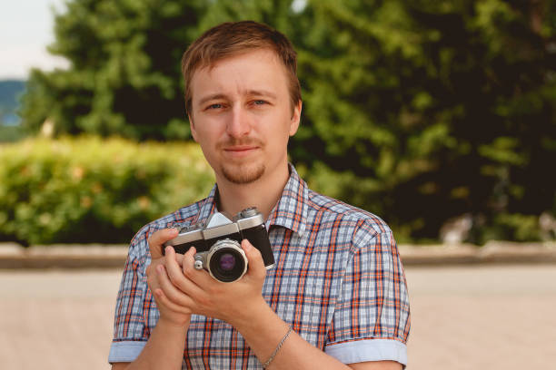 istock Happy young man holding camera taking photos photographer 693877454