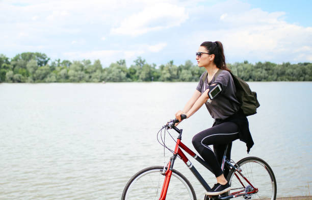 istock Young woman on the bicycle by the river 693884098