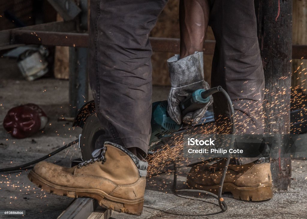 Sparks flying with boots Grinding metal with sparks flying and boots in the foreground Welding Stock Photo