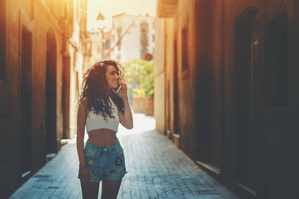 istock Curly brunette girl talking on phone 693890320