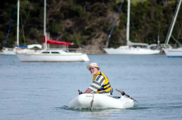 Man sails a rubber inflatable dinghy boat.