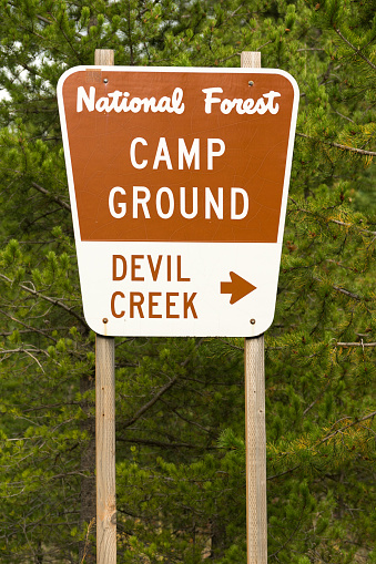 A metal sign along the highway points the way to Devil Creek Campground