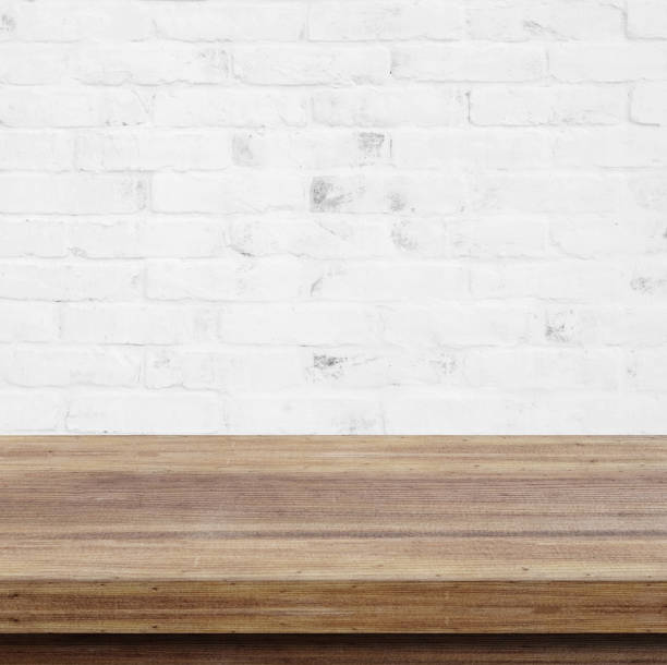 istock Empty wooden table over white brick wall  background, for product display montage 693931522