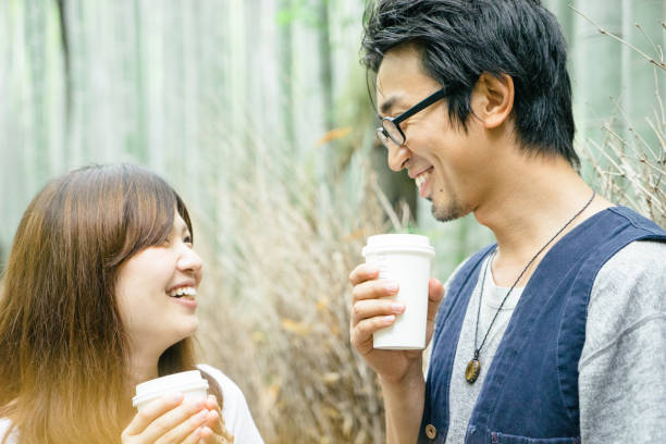 istock Cheerful Japanese couple walking through bamboo forest 693934558