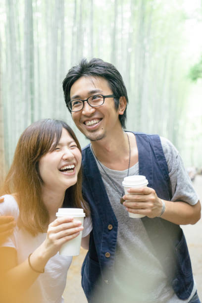 istock Cheerful Japanese couple walking through bamboo forest 693937488