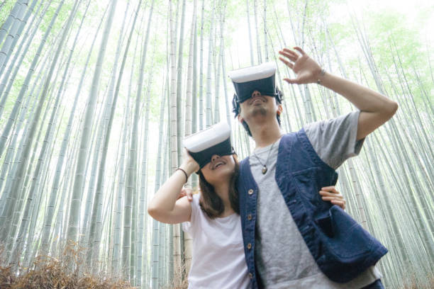 istock Japanese young couple using virtual reality simulator outdoors 693937520