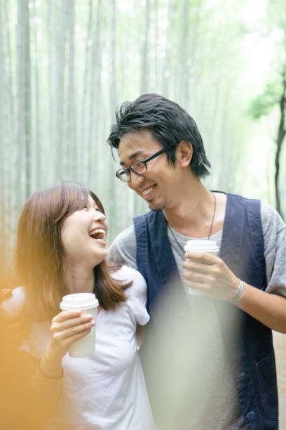 istock Cheerful Japanese couple walking through bamboo forest 693937656