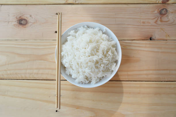 istock Jasmine rice in white cup on wood table 693964178