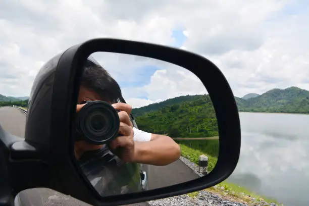 Photo of Mirror image of a photographer in the car mirror