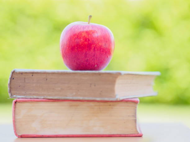 istock World Book Day concept. Red apple and pen put on stack of old books 693974926