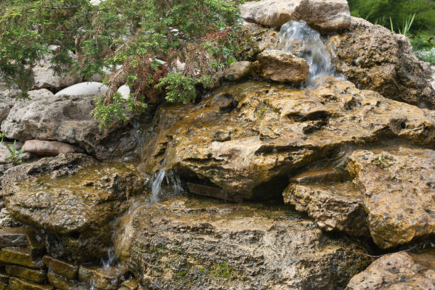 istock Composition of small artificial waterfall and stones in park 693976386