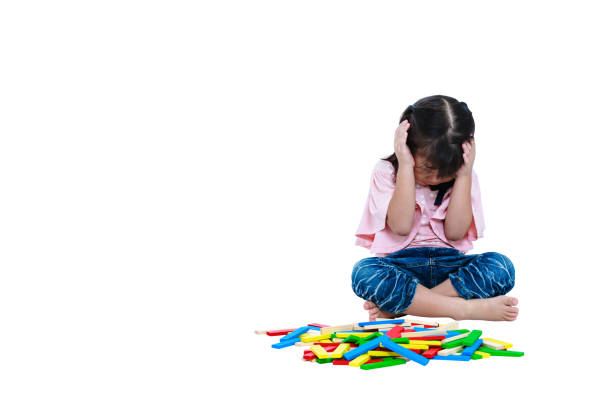 плачущий азиатский ребенок играет в игрушки и кажется несчастным. изолированный - kd стоковые фото и изображения