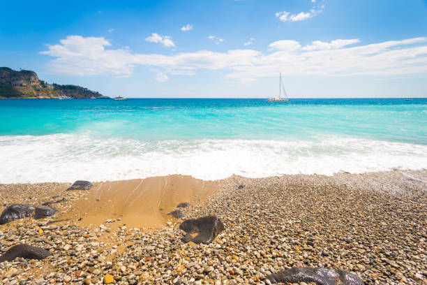 Sandy beach, yellow sand, Sailing ship on horizont. Sicily, Italy, Europe