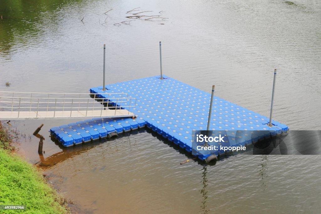 Blue plactic dock Bright blue plastic dock for parking boat or rafting in the river Commercial Dock Stock Photo