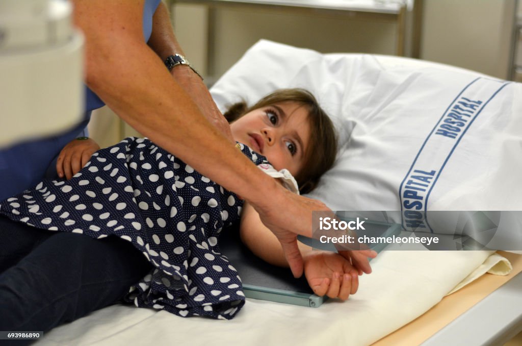 X-ray - Children Little girl prepares to receive an X-ray arm radiography. Child Stock Photo