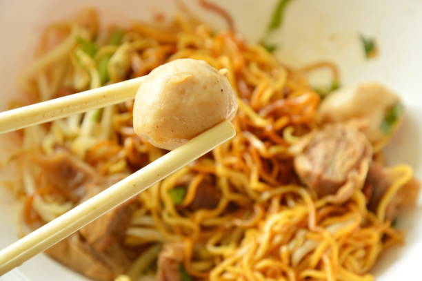 pork ball picking in white plastic chopstick on bowl