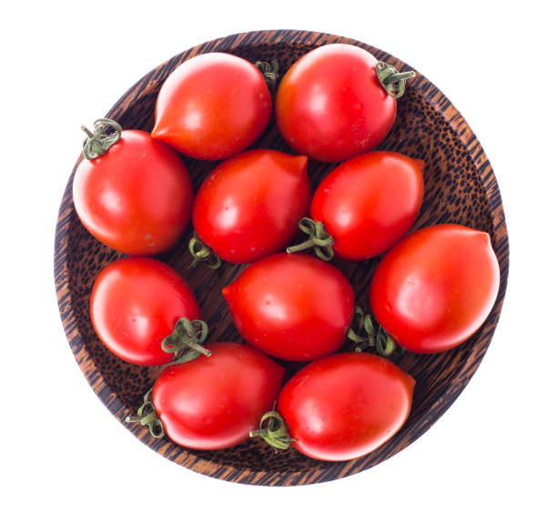 istock Red ripe tomatoes in salad bowl on white background, top view 693996404
