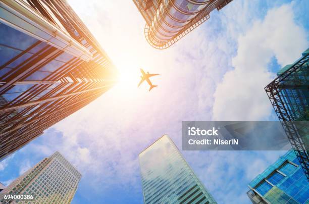 Airplane Flying Over Modern Business Skyscrapers Transport Travel Stock Photo - Download Image Now