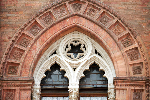 Close-up of Gothic archway over window from Bologna, Italy