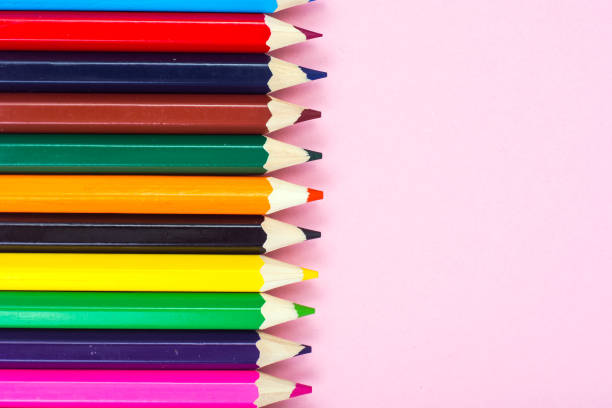 istock Multicolored pencils on pink paper background 694003906
