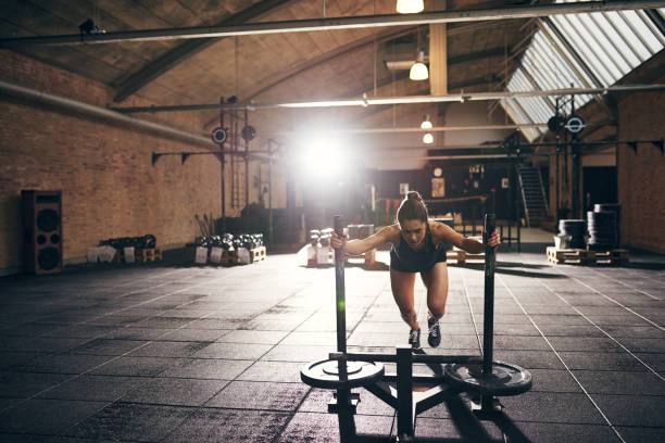istock Woman doing hard push-up exercise in gym 694004944