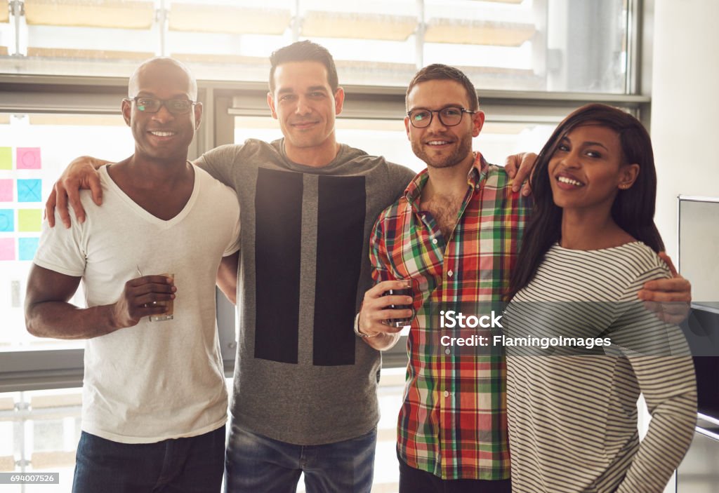 Permanente de equipo de oficina alegre con las bebidas - Foto de stock de Adulto libre de derechos