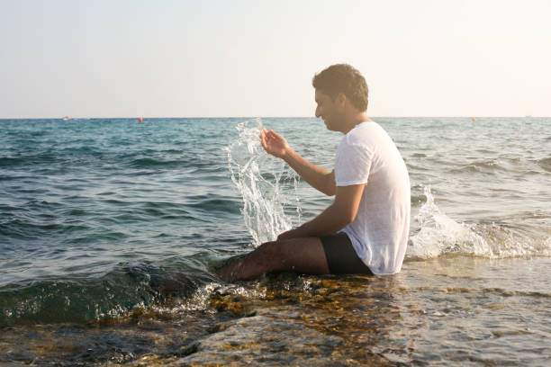 istock Arabian man on the beach. Arabian man sitting on coastline. Space for copy. 694007878