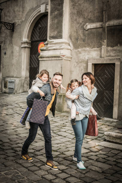istock Family was returning from shopping. Parents carrying daughters on her back. 694009780