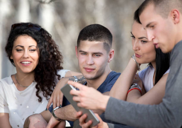 istock Group of young people looking at tablet outdoor 694010316