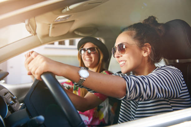 istock Two gorgeous young woman driving through town 694015974