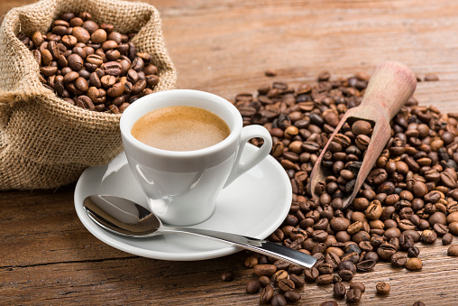 cup of coffee with coffee beans on wooden table