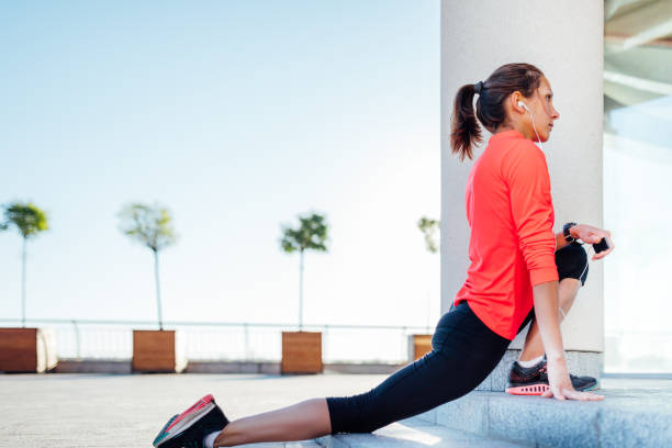 istock Young woman listening music while stretching before jogging exercise 694032668