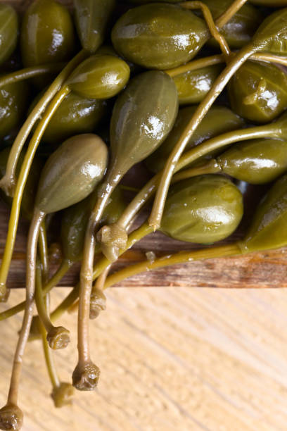istock Canned capers in wooden dish . 694032946