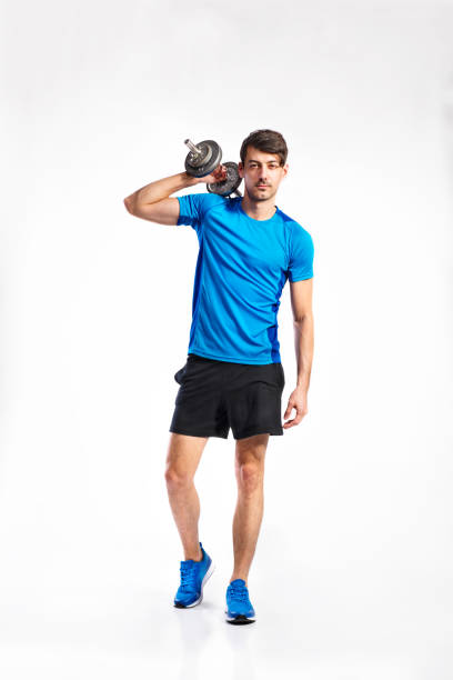 istock Fitness man holding dumbbell, working out, studio shot. 694033224