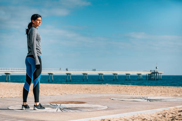 istock Young woman resting after jogging on the sandy beach 694039534