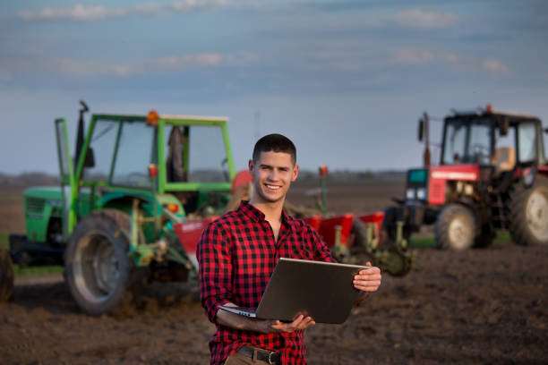 rolnik z laptopem przed sprzętem rolniczym - business agriculture equipment farm zdjęcia i obrazy z banku zdjęć