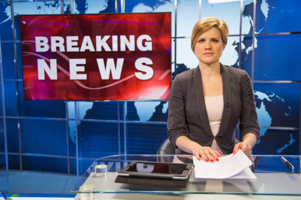 Newsreader in television studio Portrait of newsreader sitting with document in press room. woman press conference stock pictures, royalty-free photos & images