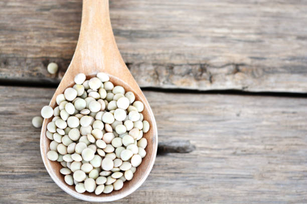 istock Lentils grains on a spoon on wooden background 694041212